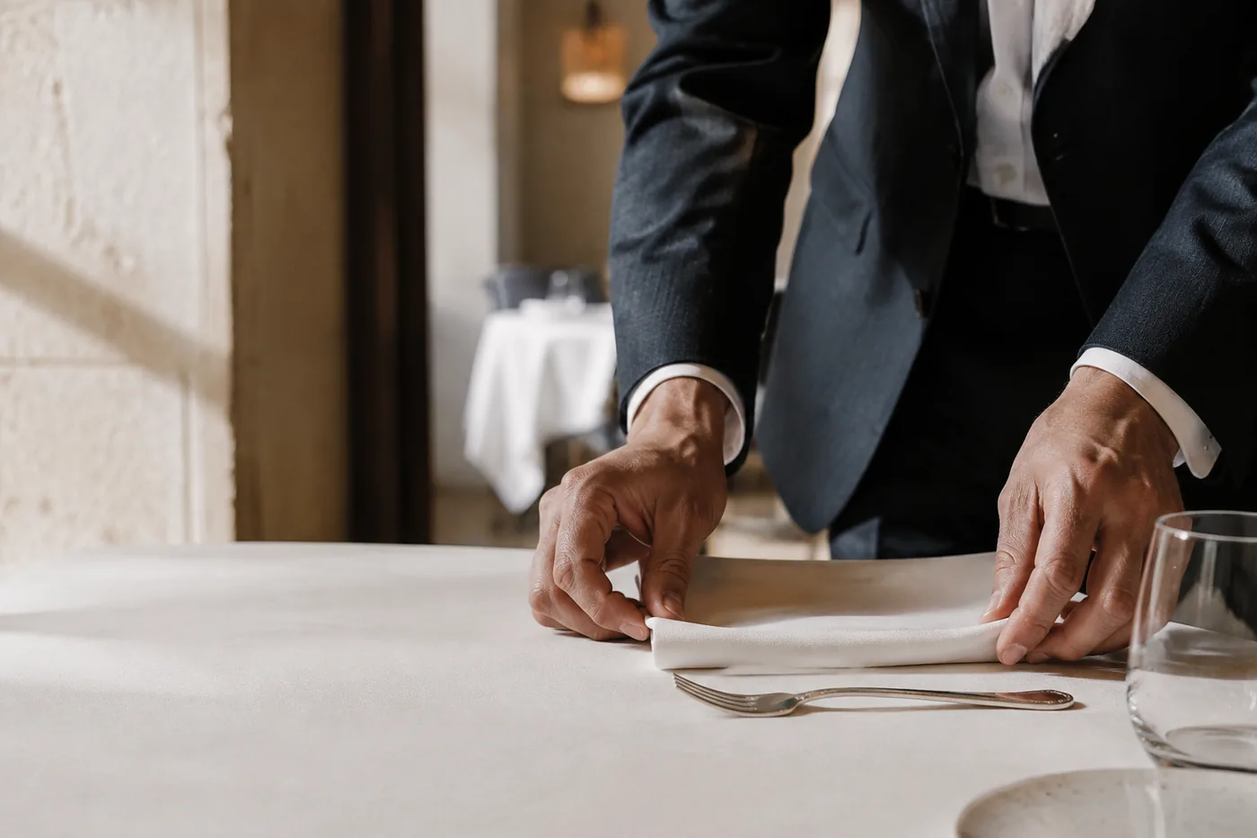 Un maître d'hôtel dresse une table